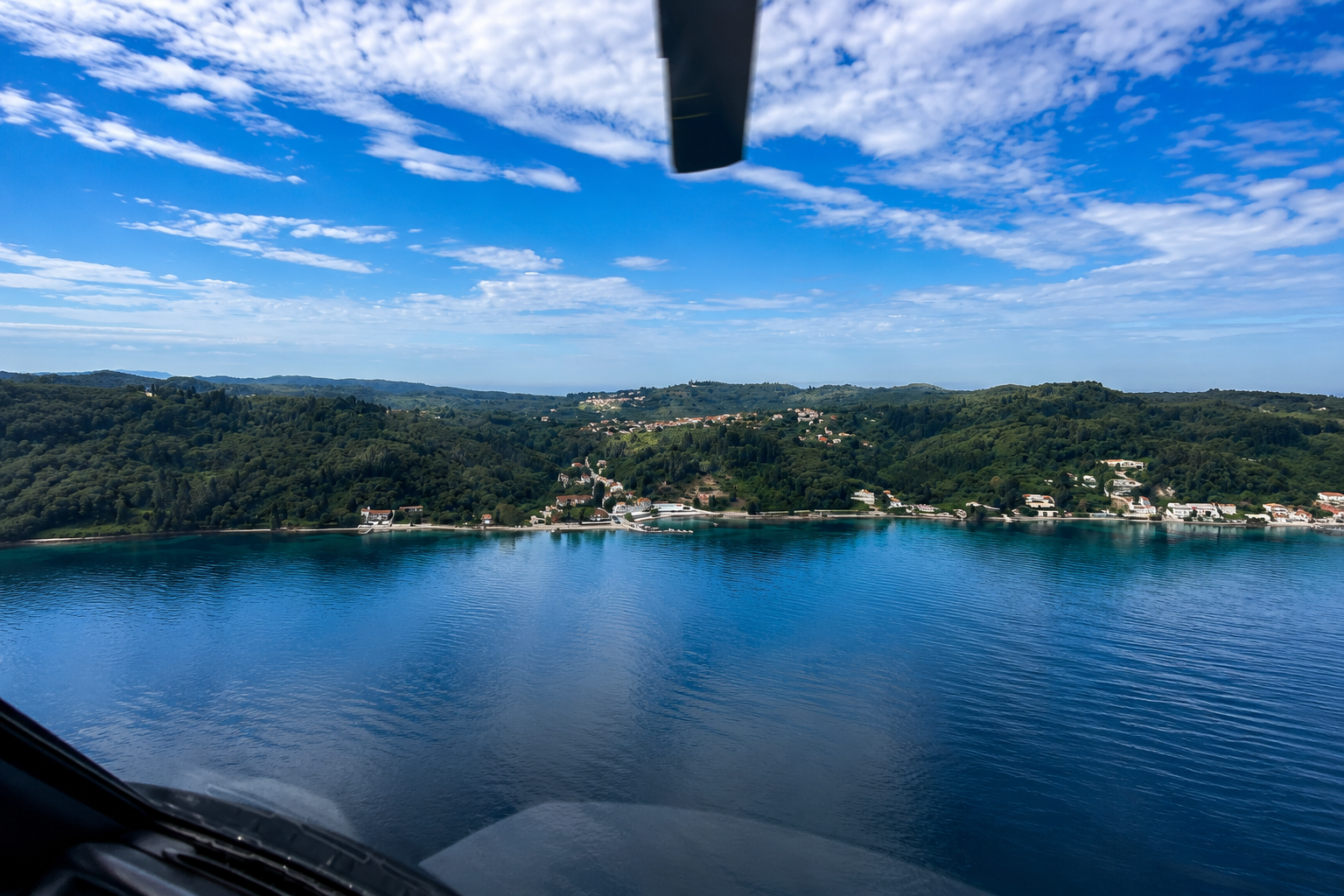 Aerial view from private helicopter approaching Paxoi (Paxos) in the Ionian Sea with coastline and turquoise water