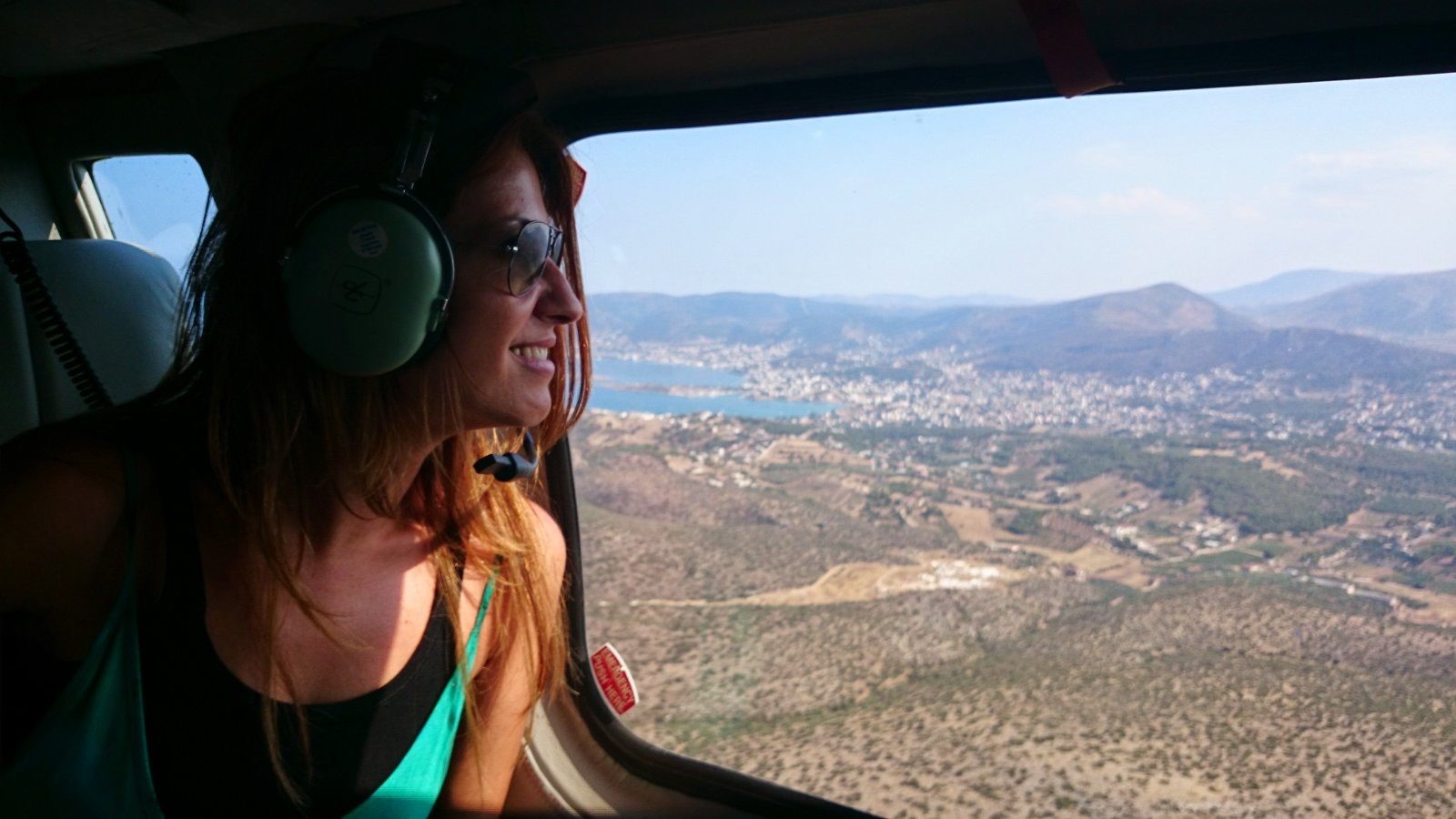 Tourist enjoying a helicopter flight over the Greek coastline during a summer vacation in Greece