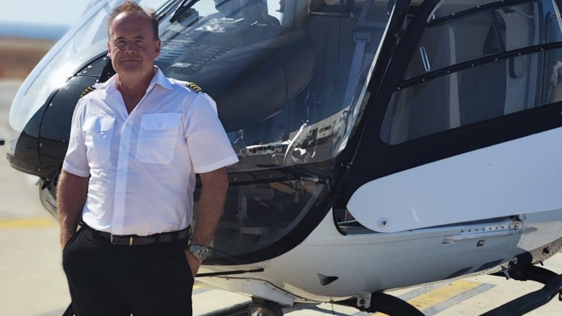 Stefan Bochdansky helicopter pilot with 3000 flight hours and 26 years as flight instructor standing beside Airbus helicopter in Greece